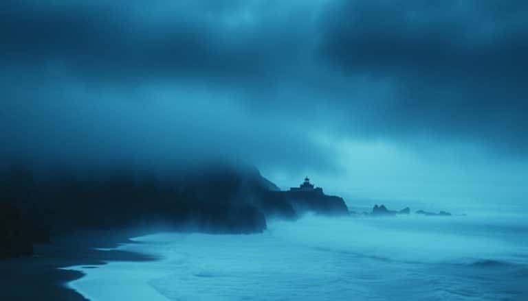 Foggy Oregon coastline with abandoned lighthouse silhouette against stormy sky at dusk - haunted Oregon Coast locations