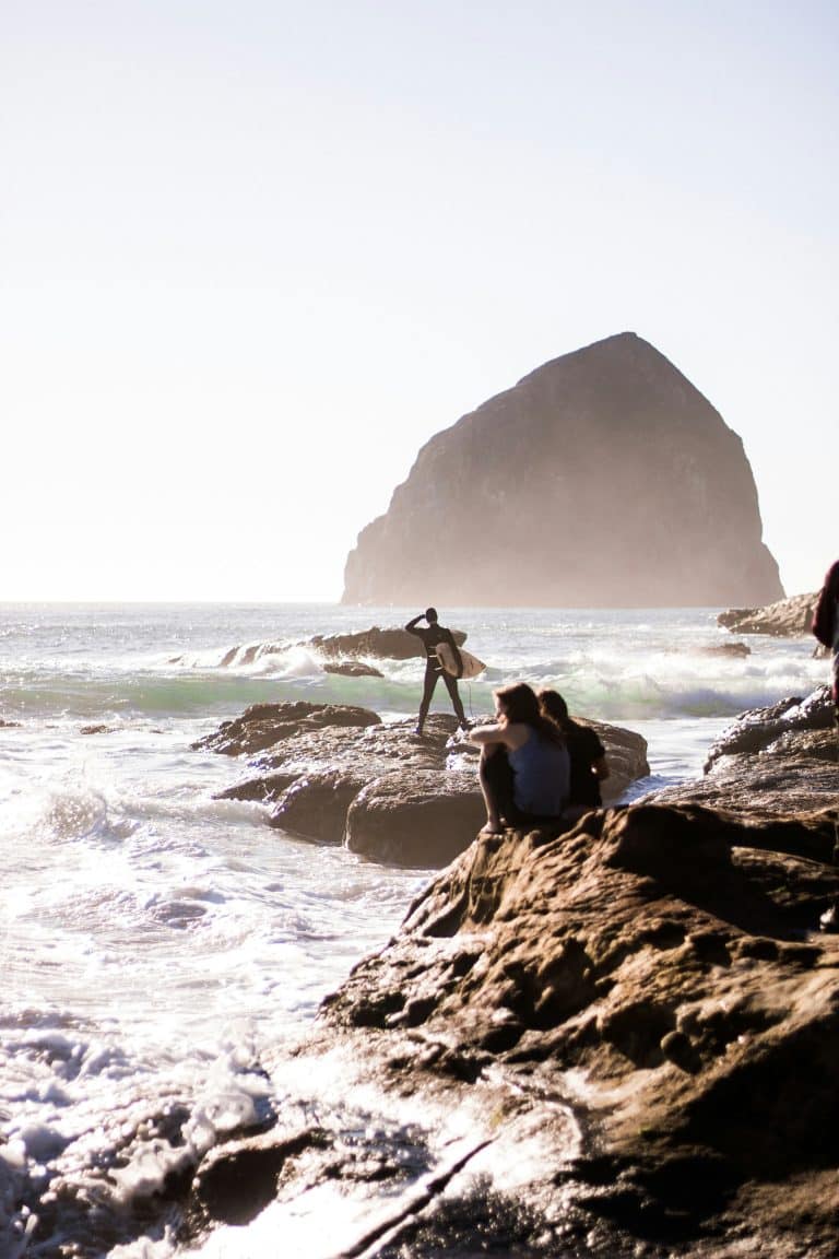 person standing on rock formation near ocean