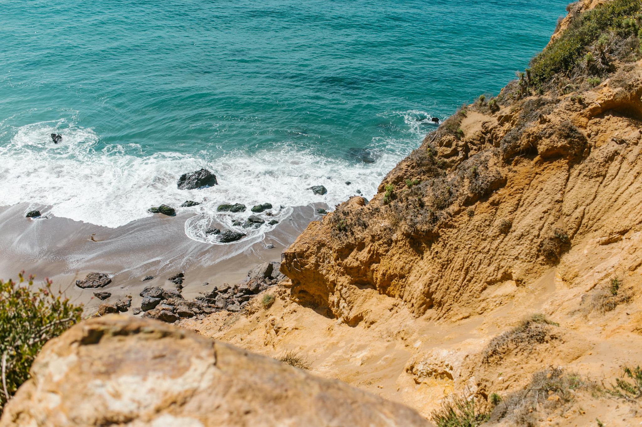 A breathtaking view of a coastal bluff with turquoise waters and rocky shorelines, perfect for nature lovers and beach explorers.