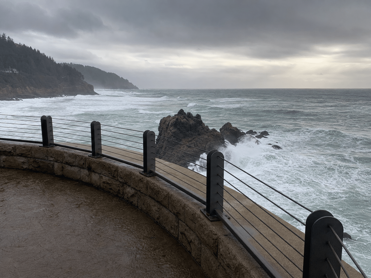 Protected elevated viewpoint overlooking rough ocean waters during coastal storm