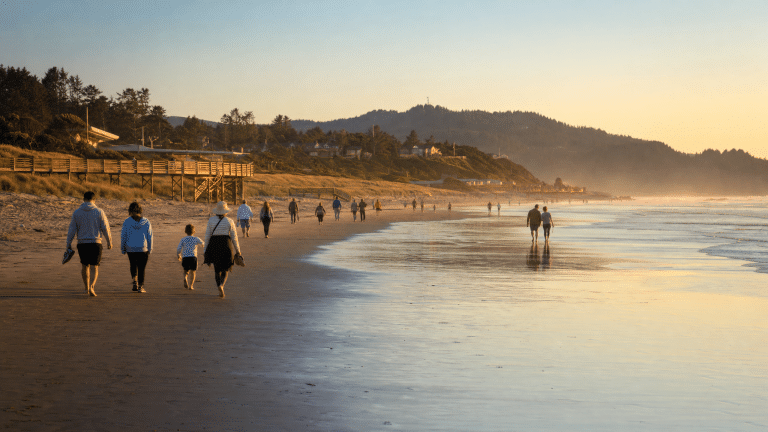 Families enjoying a wide sandy beach at sunset on the Oregon Coast