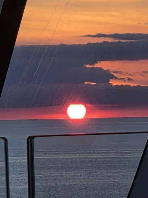 Sunset over the water from a ship lounge