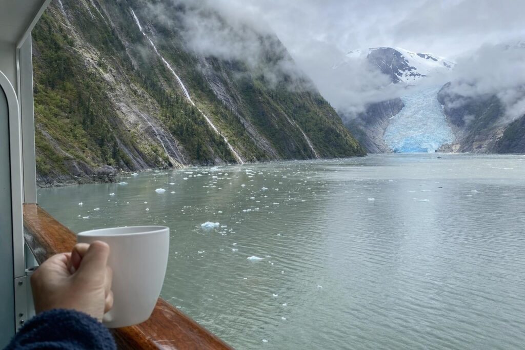 Balcony view of a glacier fjord with floating ice and misty mountains on an Alaska Inside Passage cruise