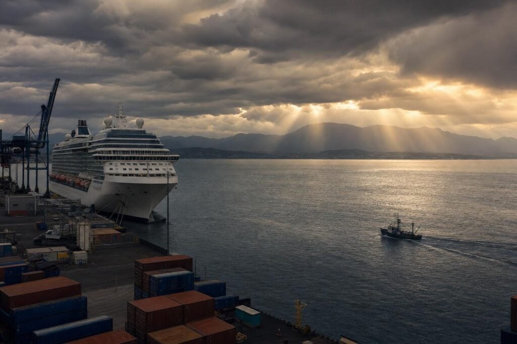 Cruise ship at a commercial harbor under storm clouds, a reminder of hurricane season on Mexican Riviera cruises