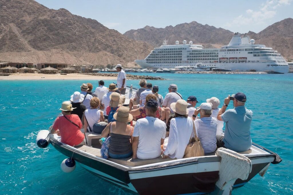 Passengers riding a tender boat from an anchored cruise ship to a beach on a Mexican Riviera port day